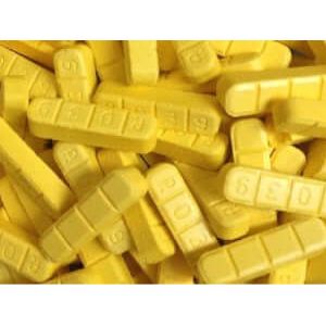 Yellow Xanax Bars (alprazolam) stacked, highlighting their rectangular shape and distinct yellow color, ideal for anxiety treatment.